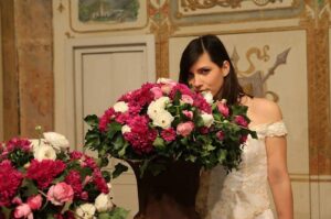 sposa che annusa fiori che suggeriscono di comprare fiori a km zero per matrimonio green umbria